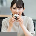 会社でおにぎりを食べるOL 5枚目