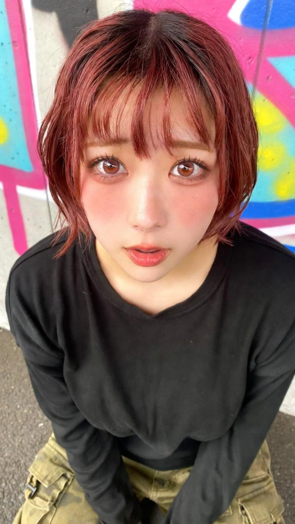 グラフィティの壁に溶け込む、赤い髪の詩