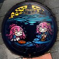 夏の風に舞うご当地マンホールに描かれた人魚と魚たちの海のアート 10枚目