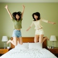ベッドで飛び跳ねる2人の女性 2枚目