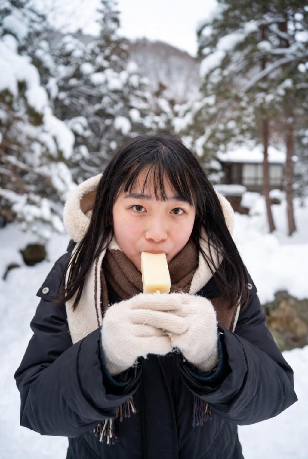雪の中、アイスを食べる女の子。