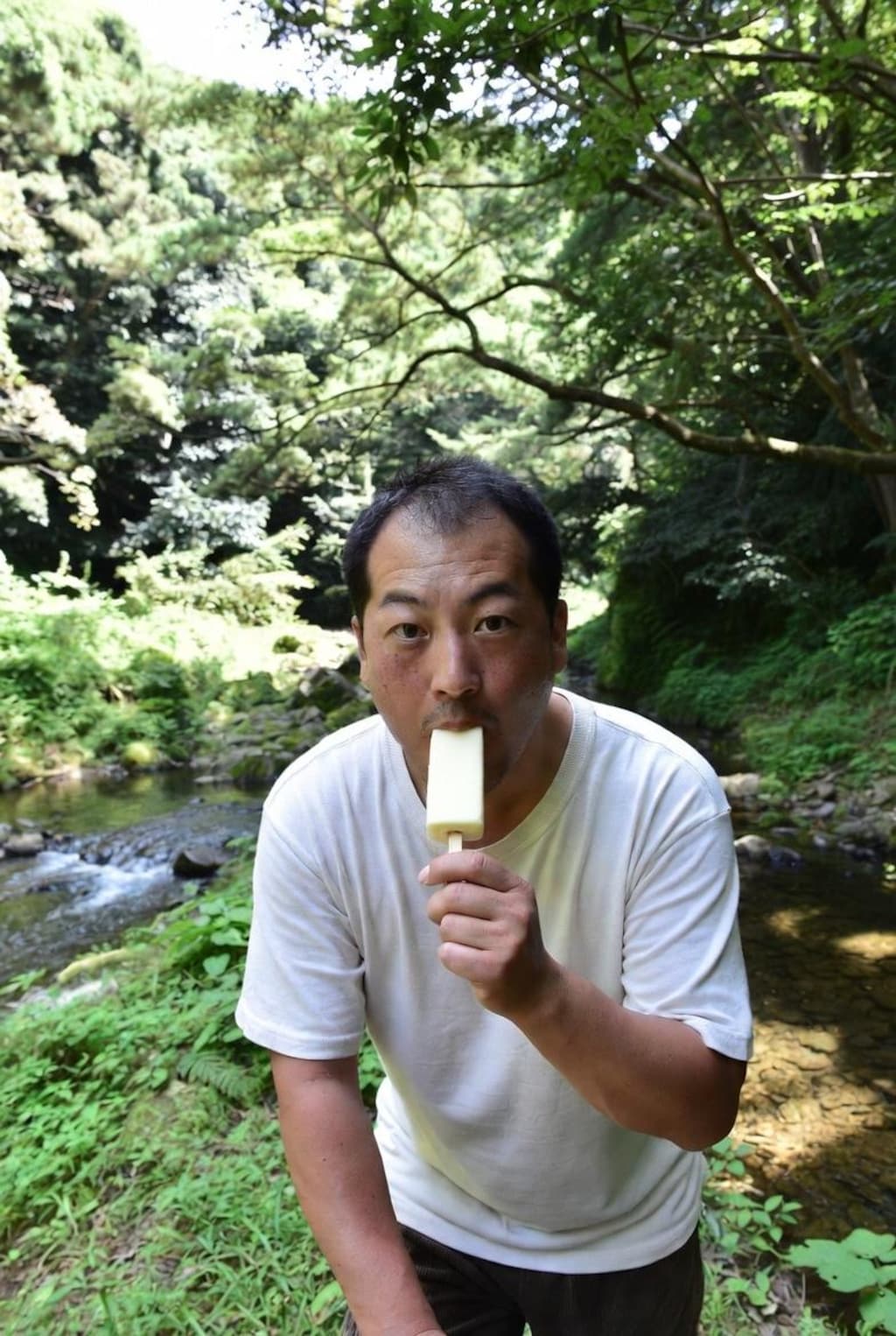 自然の中でアイスを食うおじさん。