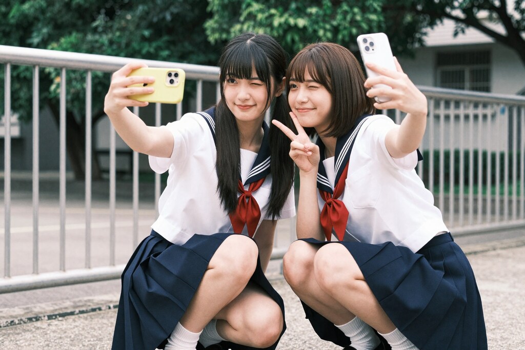 学校のフェンス前で、永遠の思い出撮り