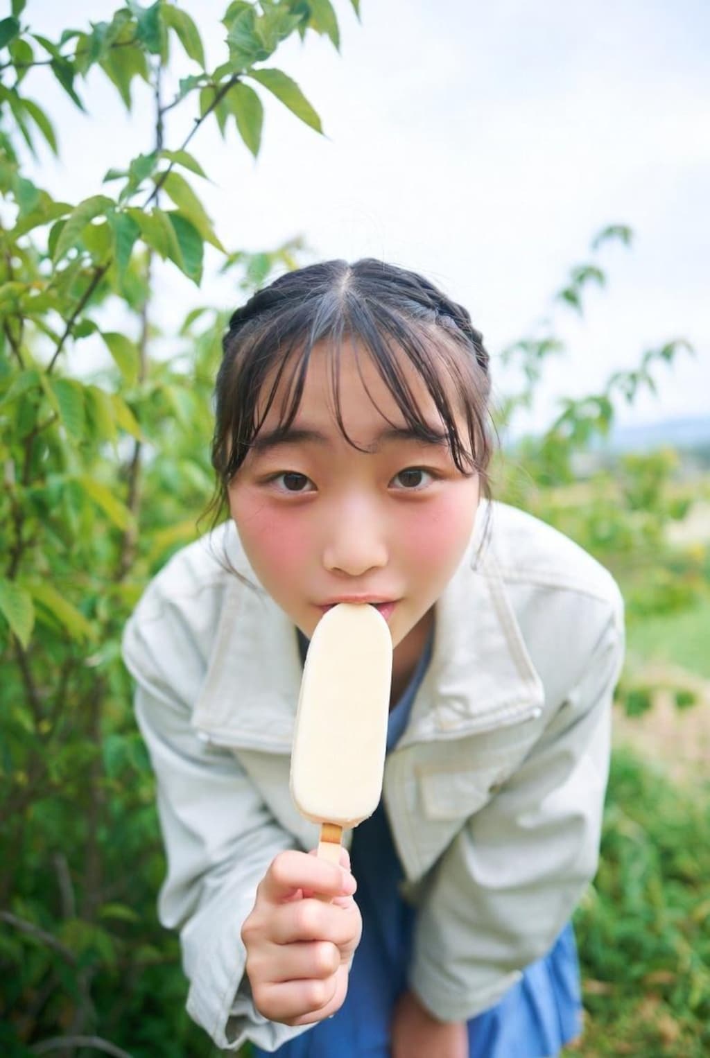 自然の中でアイスを食べる女の子