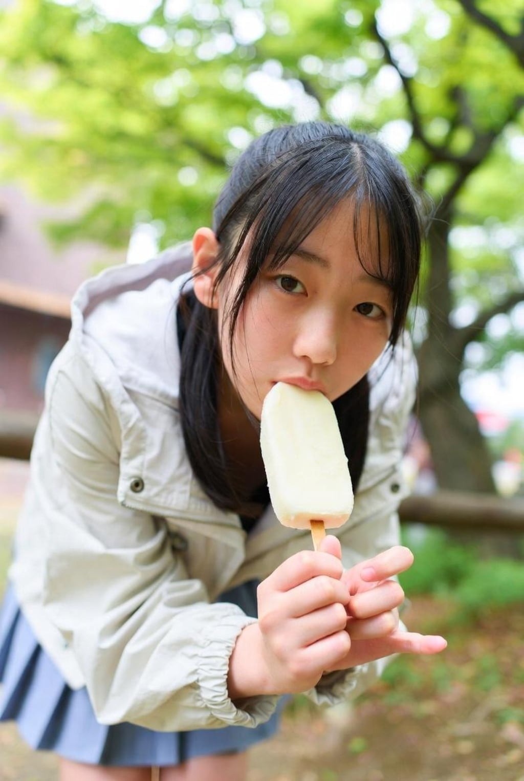 自然の中でアイスを食べる女の子