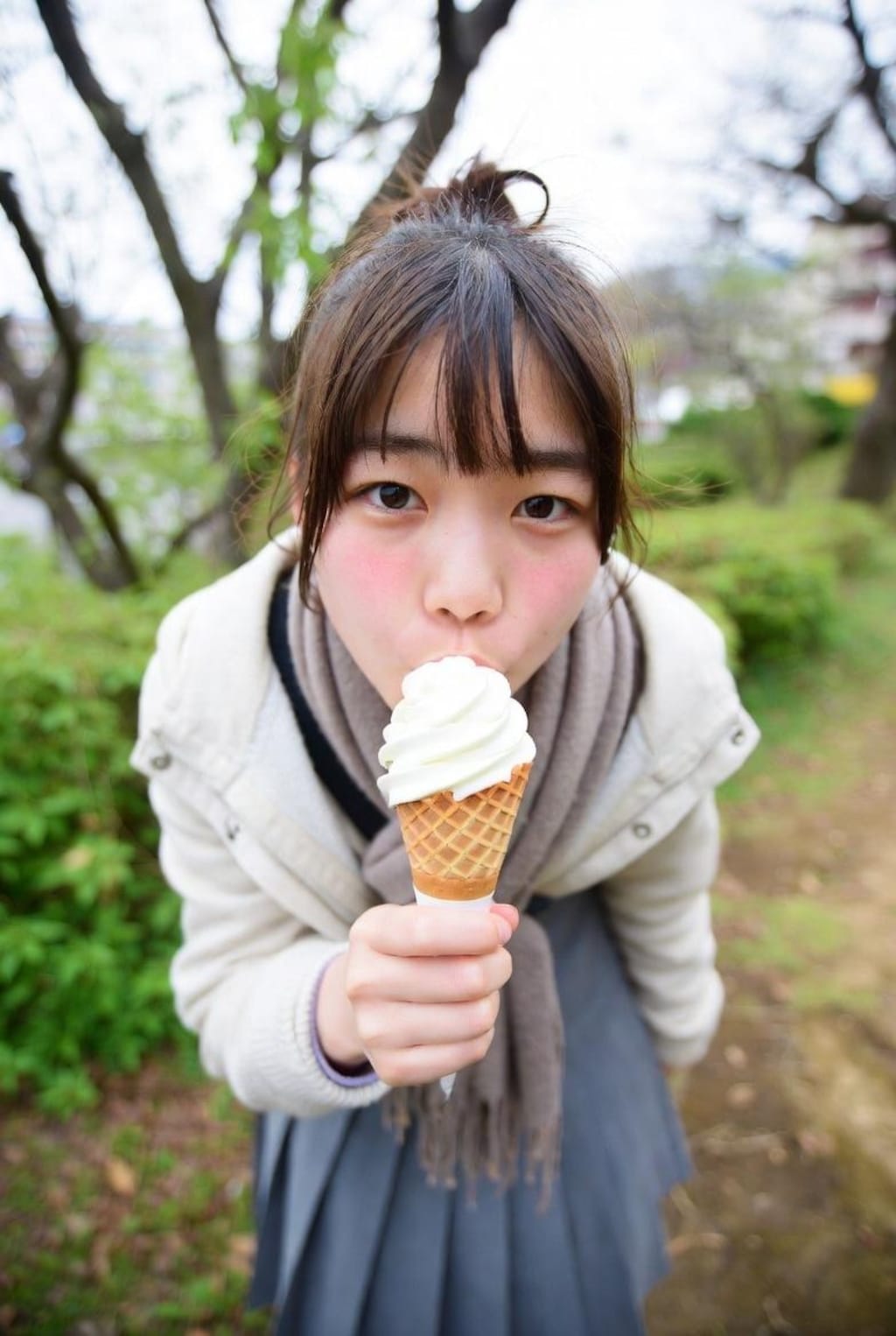 自然の中でアイスを食べる女の子