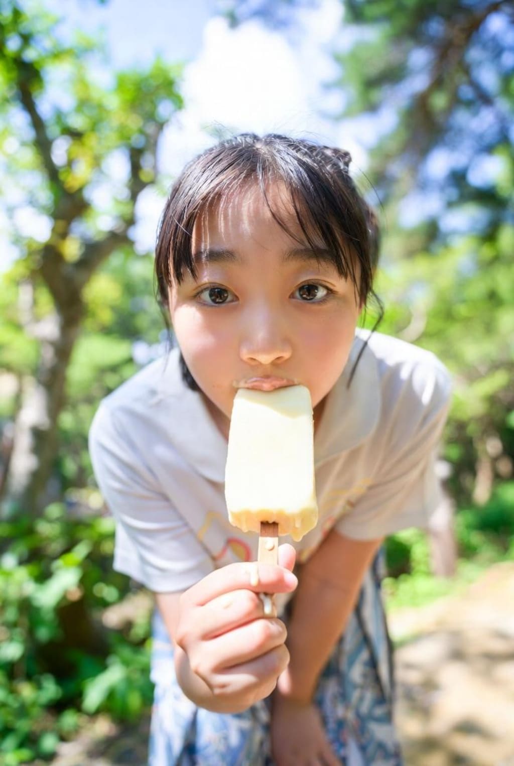 自然の中でアイスを食べる女の子